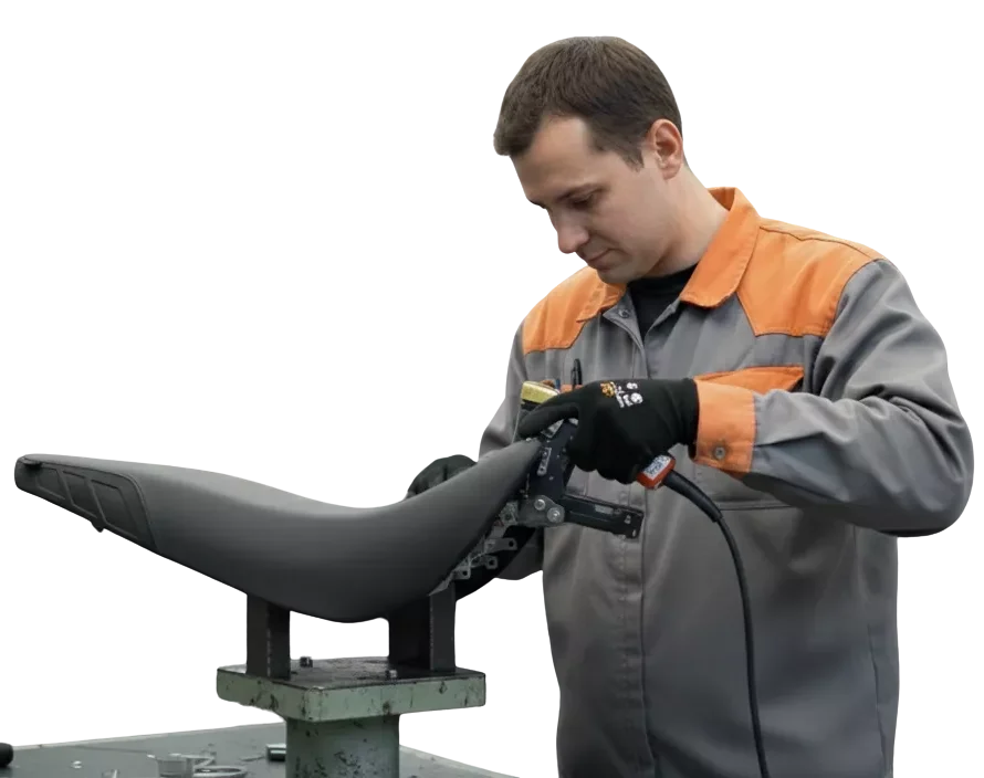 Operario en fábrica trabajando en la producción de un asiento Thermoliner, utilizando herramientas especializadas.